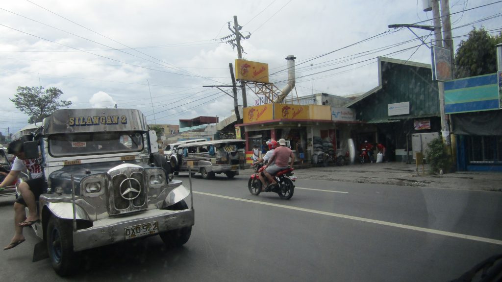 Picking up some 'lechon manok' (grilled chicken) along the way Jeepneys ply the national highway in Cabuyao, Laguna