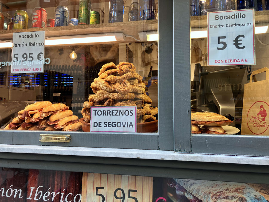 An assortment of meat delicacies and other Spanish food products entice visitors and whet their appetites as they meander the narrow streets of Segovia. An assortment of meat delicacies and other Spanish food products entice visitors and whet their appetites as they meander the narrow streets of Segovia.