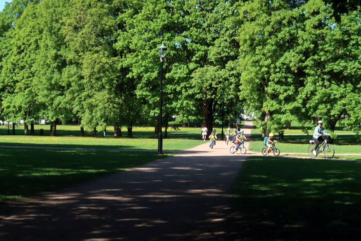 A family cycles inside the Frogner Park in Oslo, Norway.